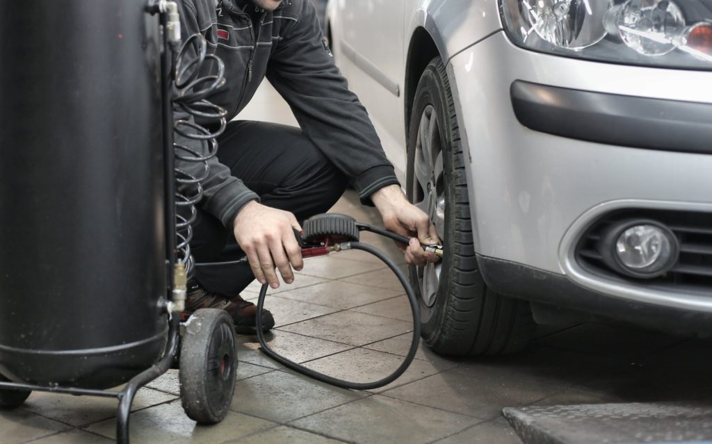 man in black jacket and black pants sitting near silver vehicle